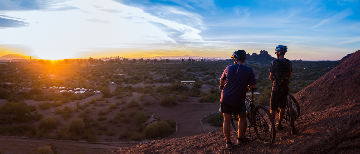 Two men can be seen looking at the horizon on a scene bike trail