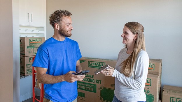 A woman shows her phone to a Moving Help Service Provider
