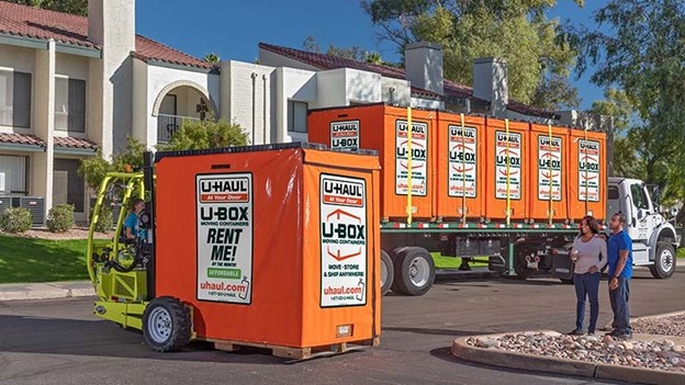 A couple waits for their U-Box storage containers to be unloaded from a truck