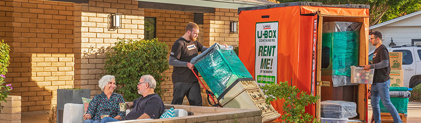 seniors relaxing as Moving Help providers load a U-Box portable moving and storage container