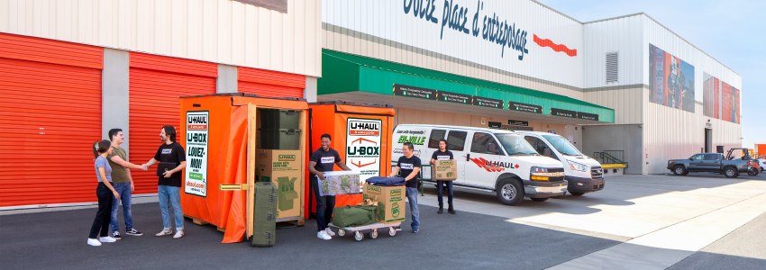 Movers help a couple unload their U-Box container at a U-Haul storage facility.