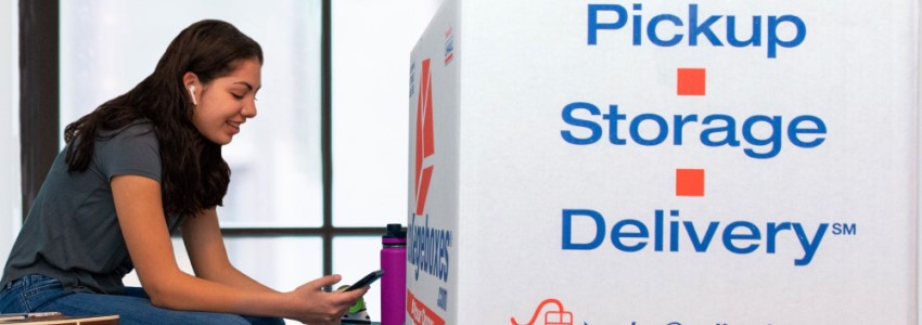 A college student is sitting with Collegeboxes stacked next to her.
