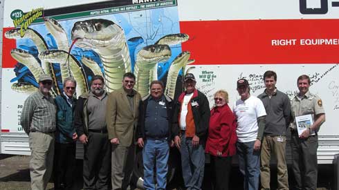 Dr. Robert Mason, Jack Dubois, John Rudyk, James Bezan, Ralph Hazelton, Gail McDonald, Real Faucher, Paul Hancock and Dave Roberts pose in front of the commemorative SuperGraphic truck.