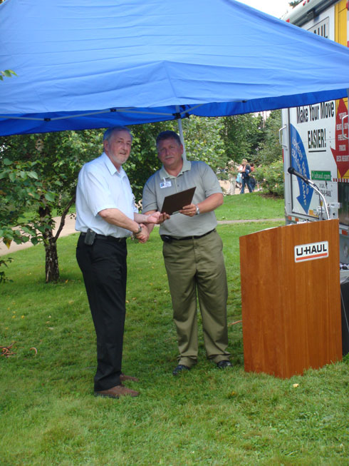 Bruce Bennett presents a plaque to Wayne Steeves, member of the legislative assembly for Albert County.