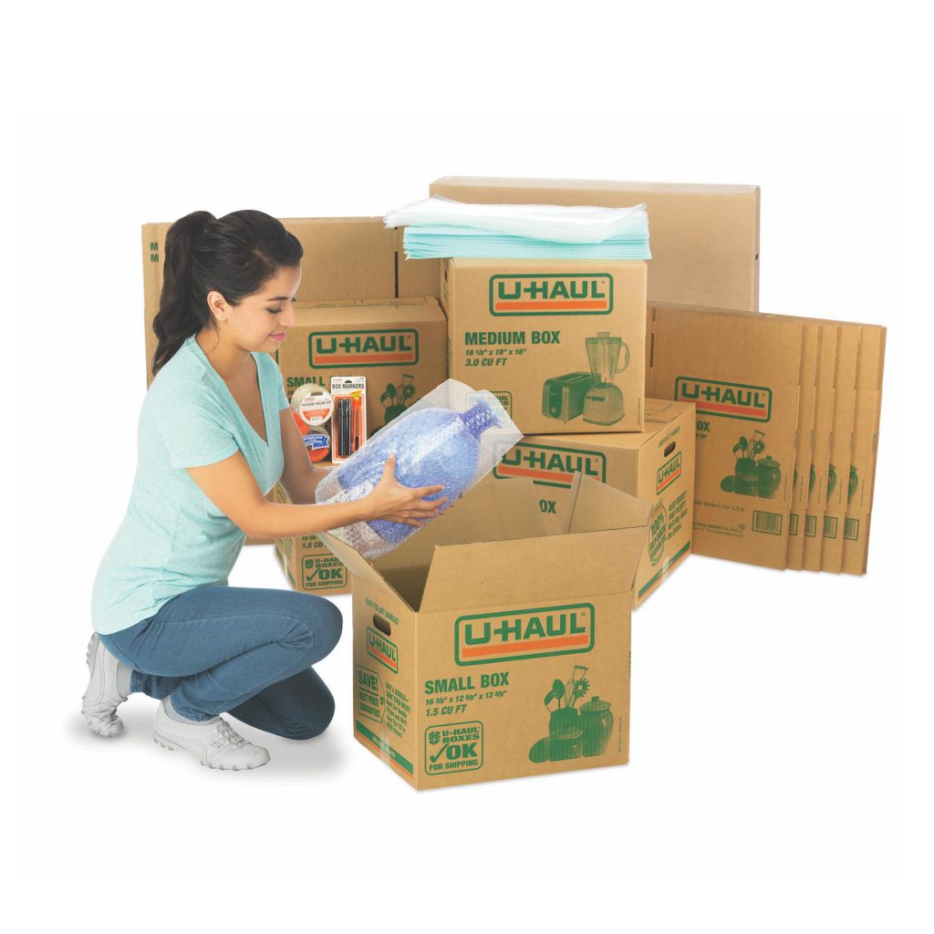 Woman packing boxes using tips and tools for small moves.